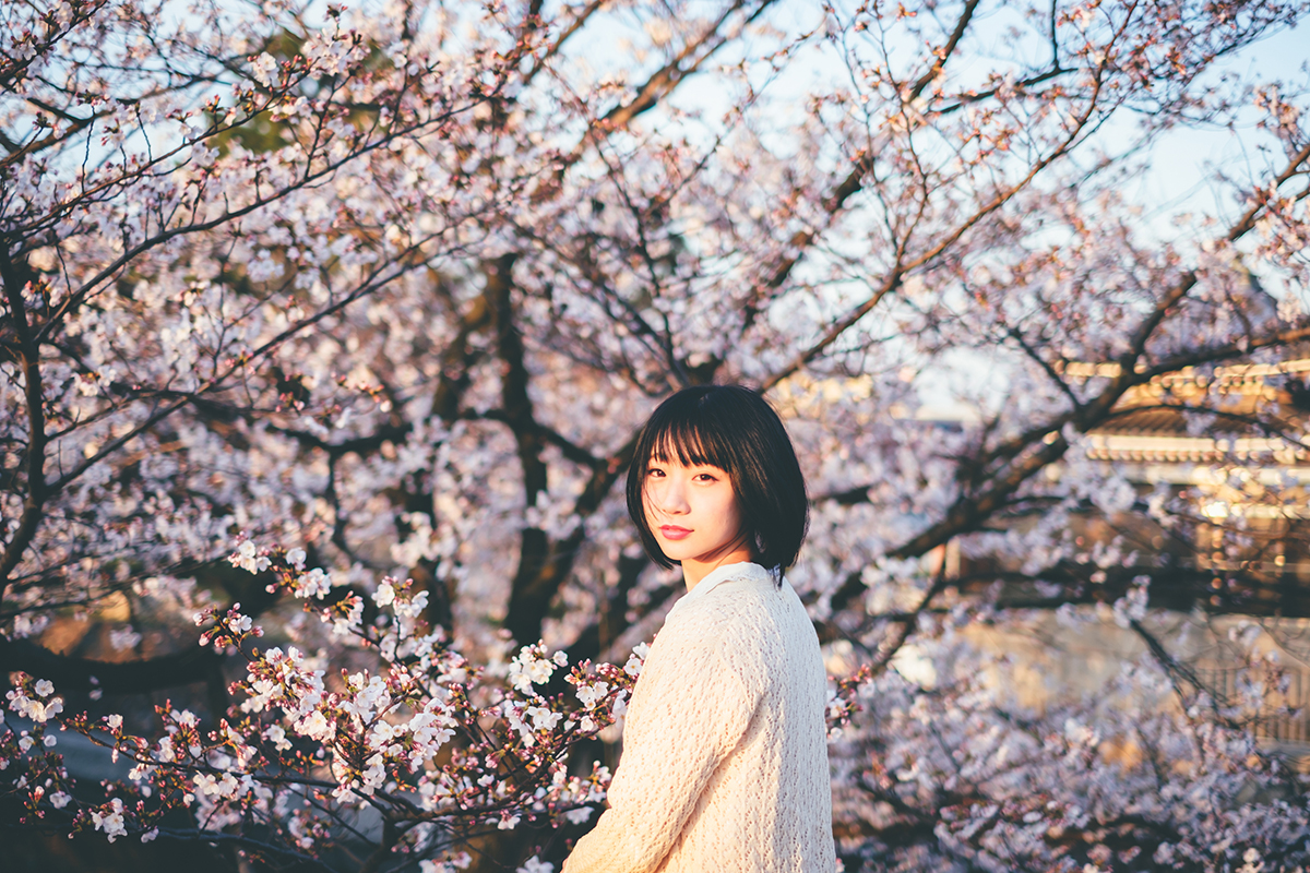 モデルさんの存在感や表情にフォーカスし、桜を背景にした写真